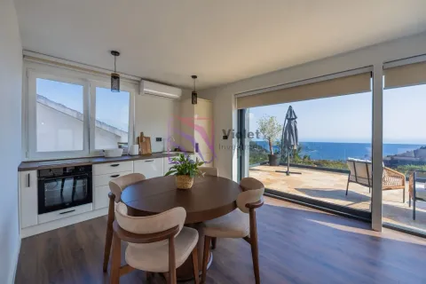 Modern kitchen with a dining area and a sea view. - image 8