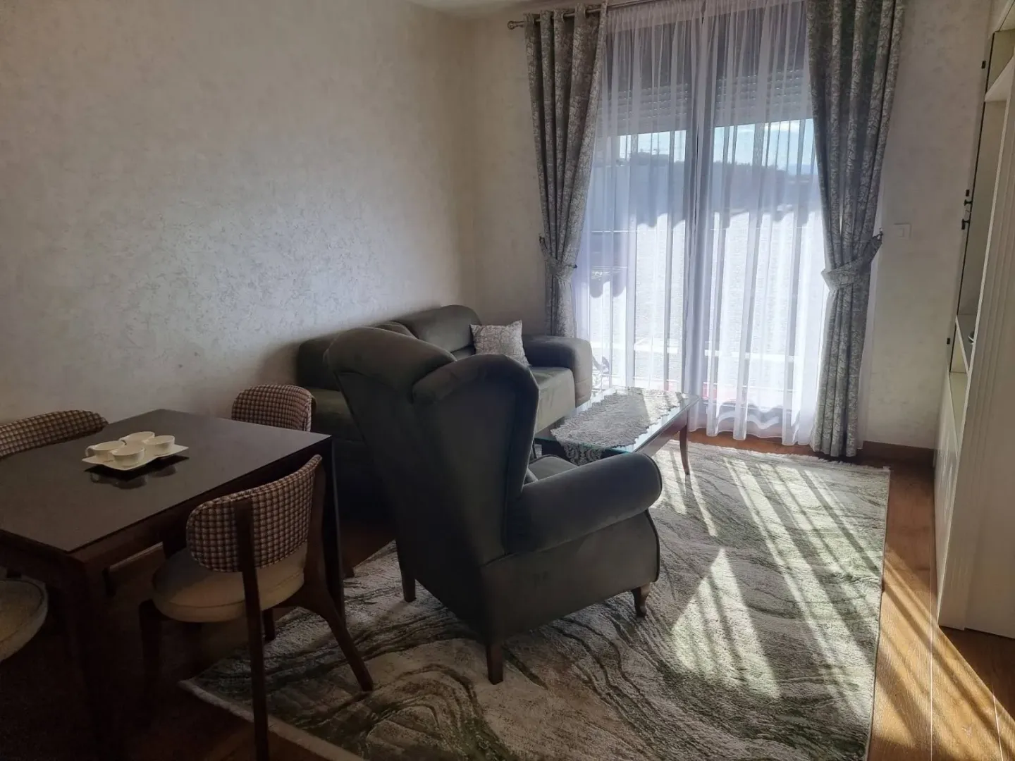 Bright living room with a seating area and a small dining table.