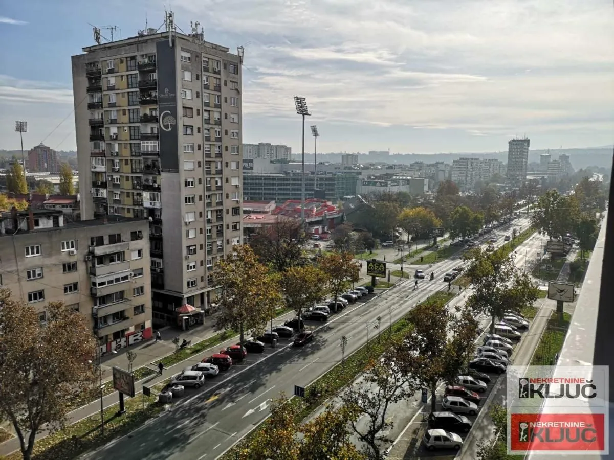 Pogled sa prozora na gradsku ulicu i okolne zgrade.