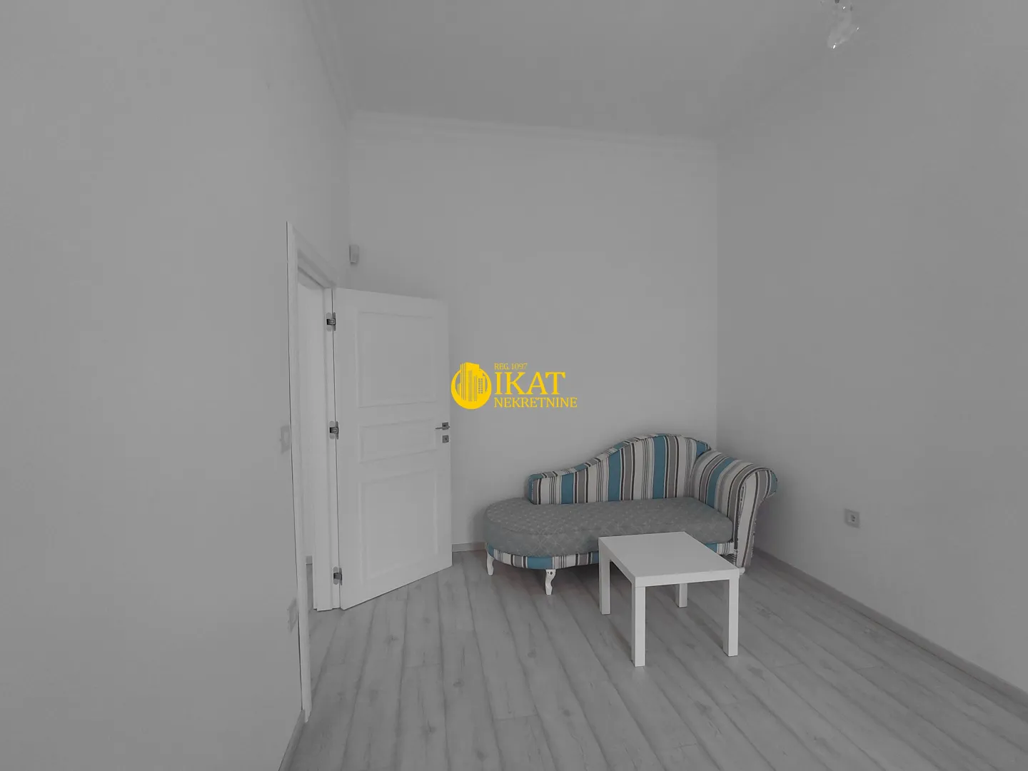 Smaller room with a striped daybed and a white coffee table.