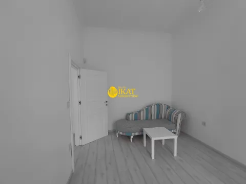 Smaller room with a striped daybed and a white coffee table. - image 4
