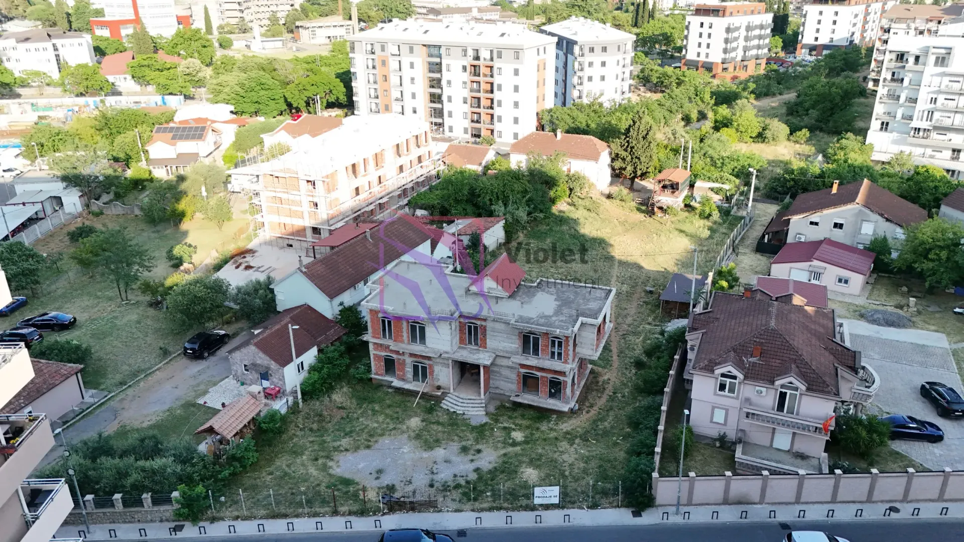 Pogled iz vazduha na građevinsku parcelu sa kućom u izgradnji i okruženjem.