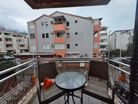 Small furnished balcony with a small table and two chairs, overlooking neighboring buildings. - image 19