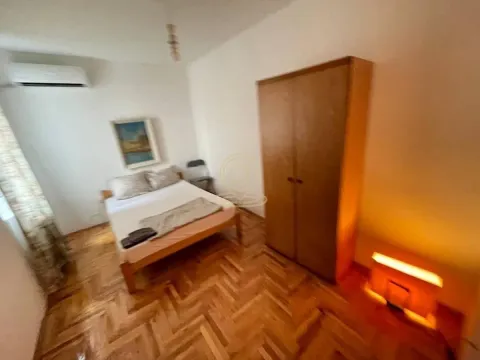 Furnished bedroom with a double bed, wooden wardrobe, and parquet flooring. - image 5