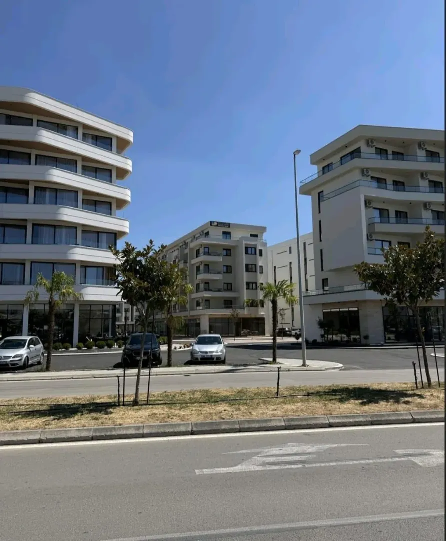 Moderne stambene zgrade sa uređenim dvorištem i parkingom.
