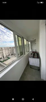 Zastakljeni balkon sa sušačem za veš i pogledom na naselje. - image 12