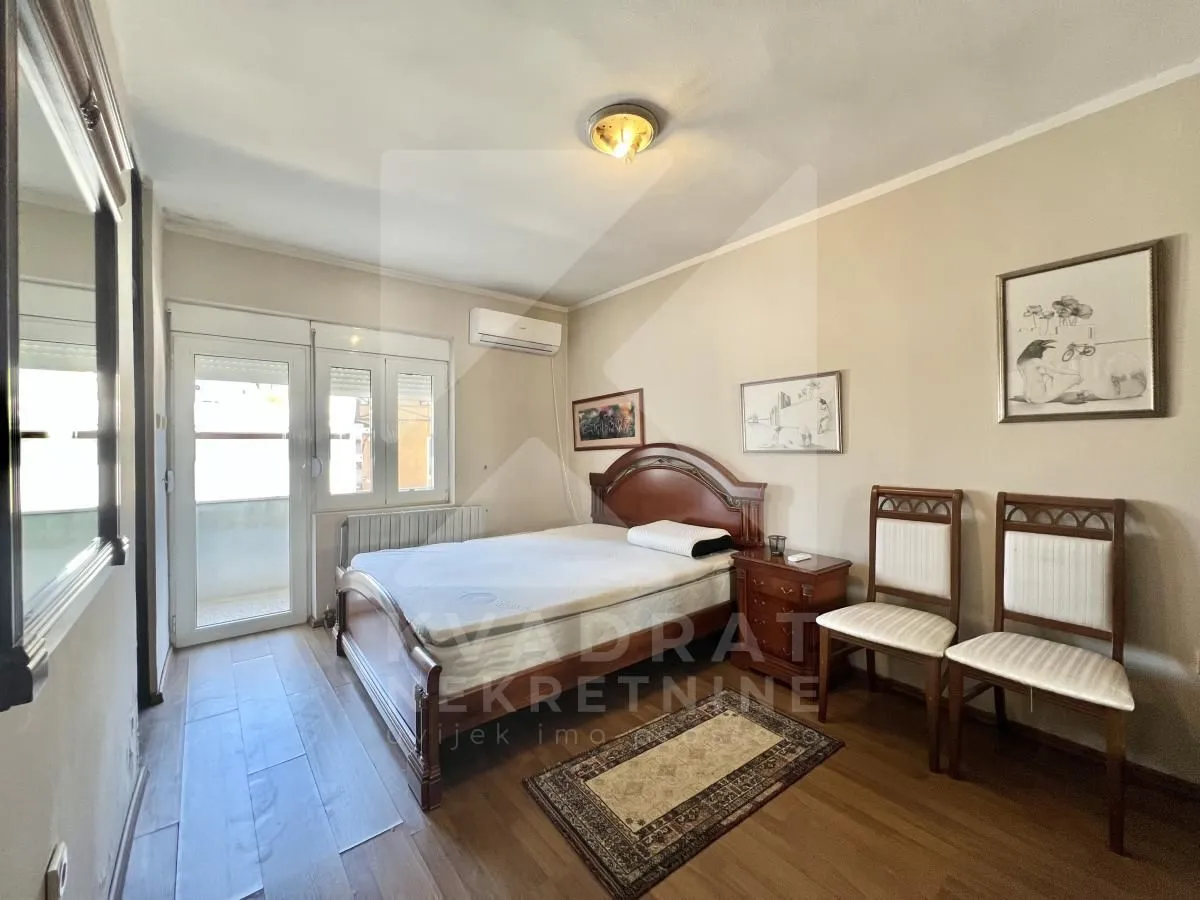 Bedroom with a double bed, wooden furniture, and access to the terrace.