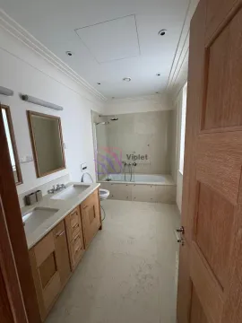 Spacious bathroom with a double vanity, bathtub, and glass partition. - image 8