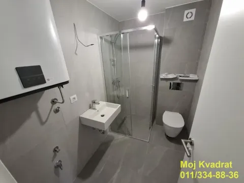 Manje kupatilo sa tuš kabinom, umivaonikom i ugrađenom wc šoljom. - image 7