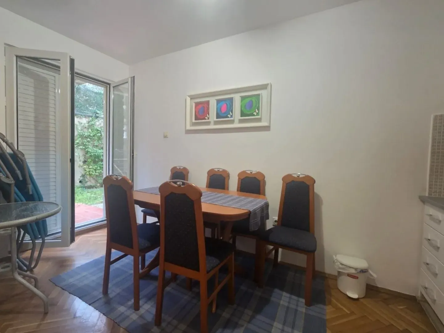 Dining area with a wooden table and chairs and access to the terrace.