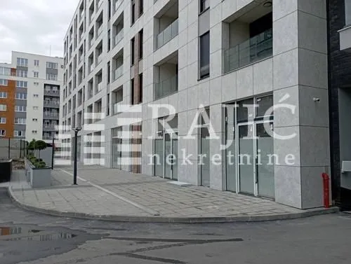 Exterior of a modern residential building with commercial space on the ground floor.