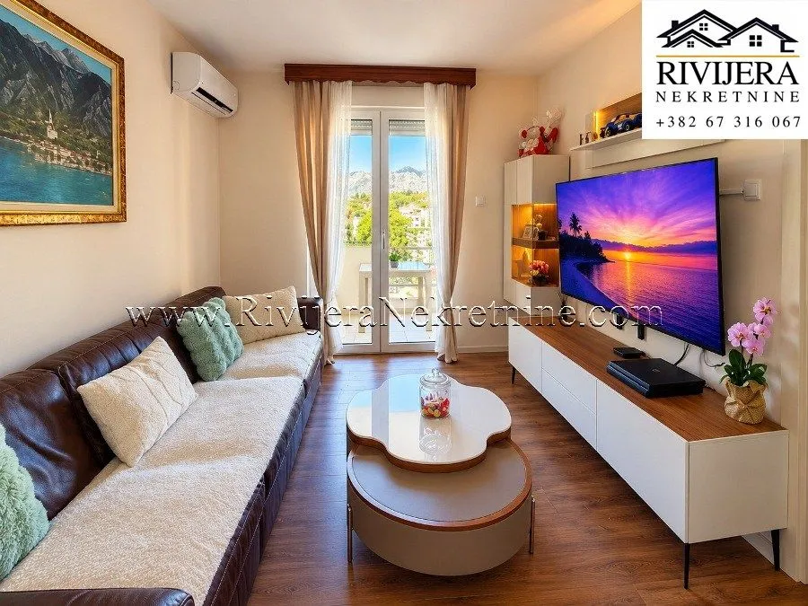 Living room with a sofa, TV, and access to the terrace.