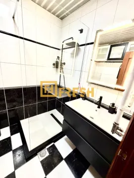 Modern bathroom with a walk-in shower and vanity. - image 11