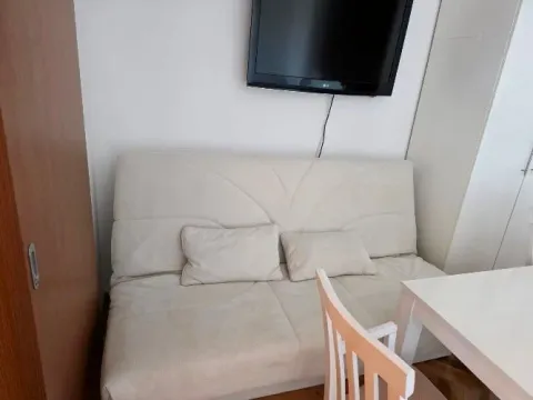 Dnevni boravak sa trosjedom, televizorom na zidu i trpezarijskim stolom. - image 5