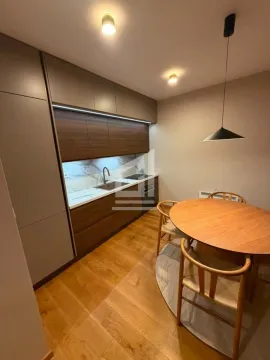 Modern kitchen with built-in cabinetry and a dining table with chairs. - image 6
