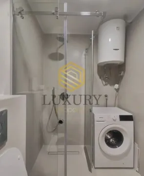 Modern equipped bathroom with a shower cabin and washing machine. - image 6