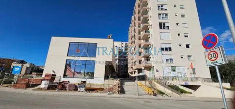 Pogled na spoljašnjost zgrade sa okolnim prostorom i saobraćajnim znakovima. - image 14