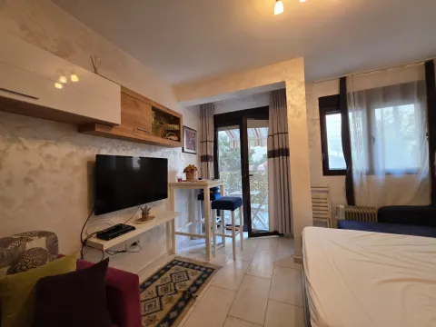 Dnevna soba sa televizorom, garniturom i izlazom na terasu. - image 2