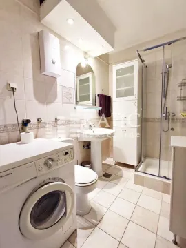 Bathroom equipped with sanitary fixtures, a shower cabin, and a washing machine. - image 15