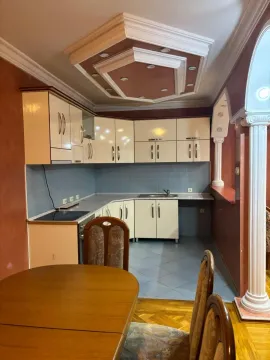 Kitchen with dining area equipped with light-colored cabinets and a decorative ceiling. - image 5