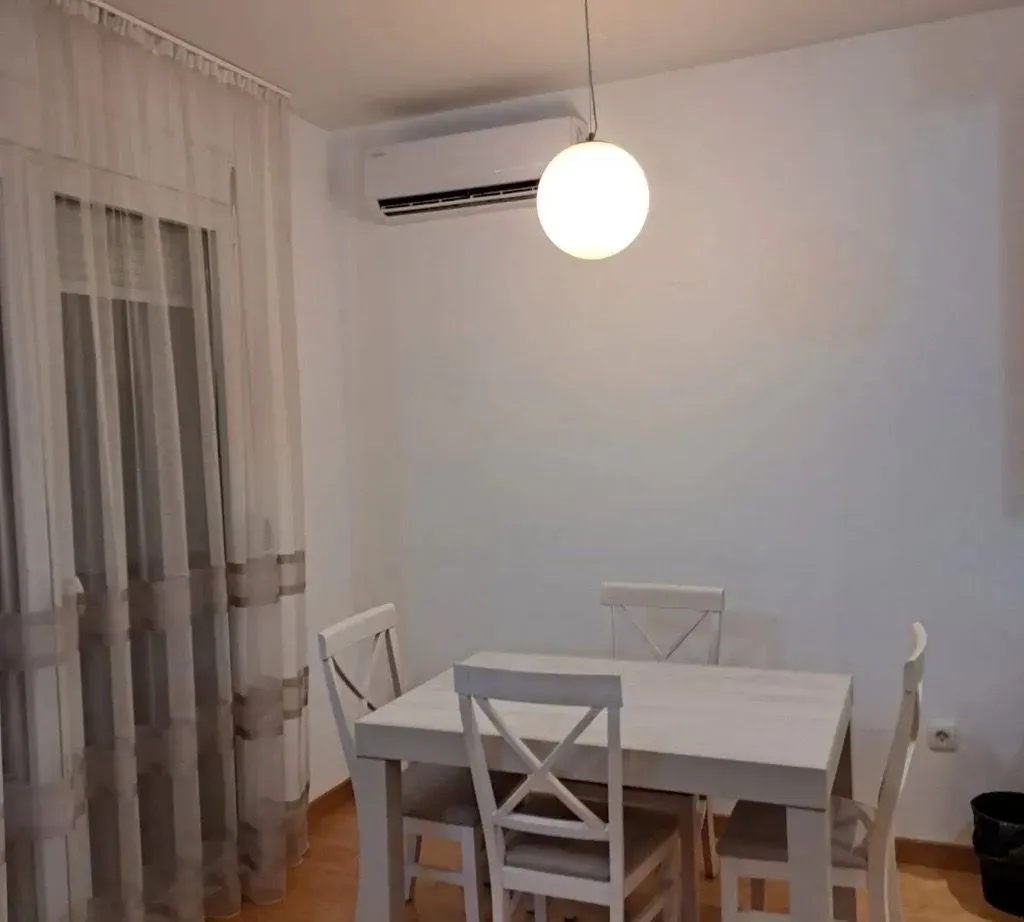 Dining area with a white table and chairs.