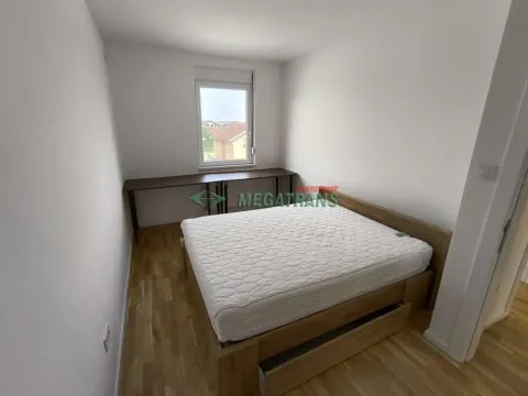 Nameštena spavaća soba sa bračnim krevetom i radnim stolom ispod prozora. - image 9