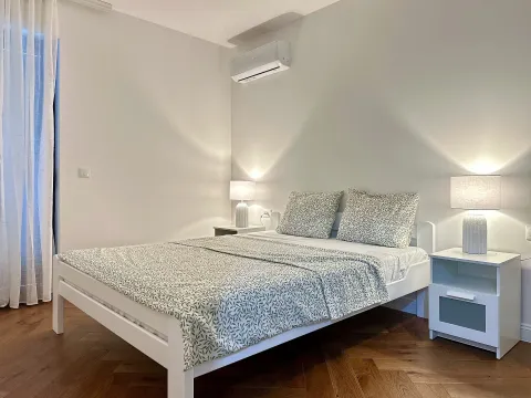 Spavaća soba sa bračnim krevetom, noćnim stočićima i klima uređajem. - image 13
