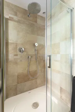 Moderna tuš kabina sa staklenim vratima i bež pločicama. - image 8