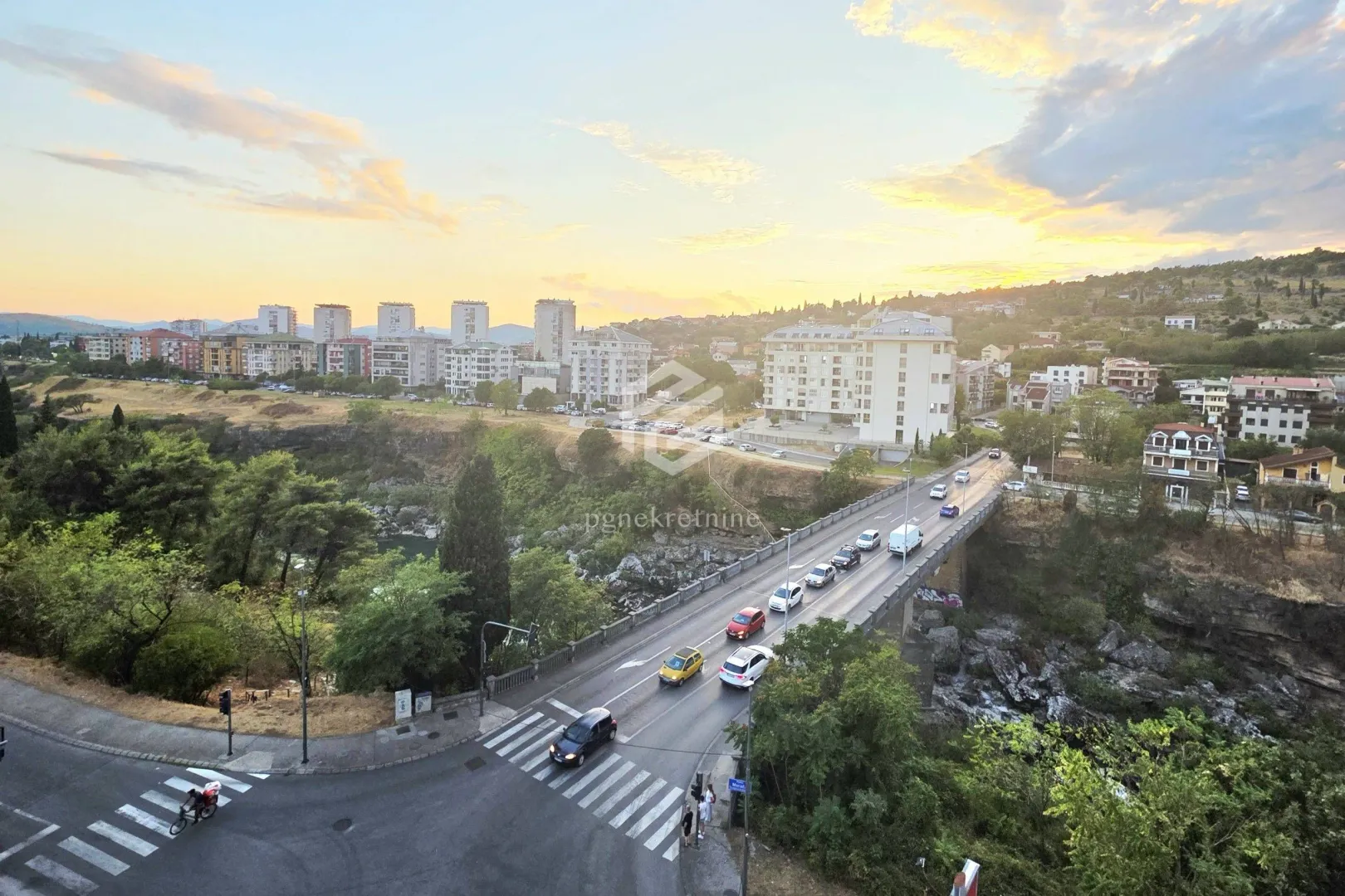 View from the window of the city bridge and surrounding neighborhood during sunset.
