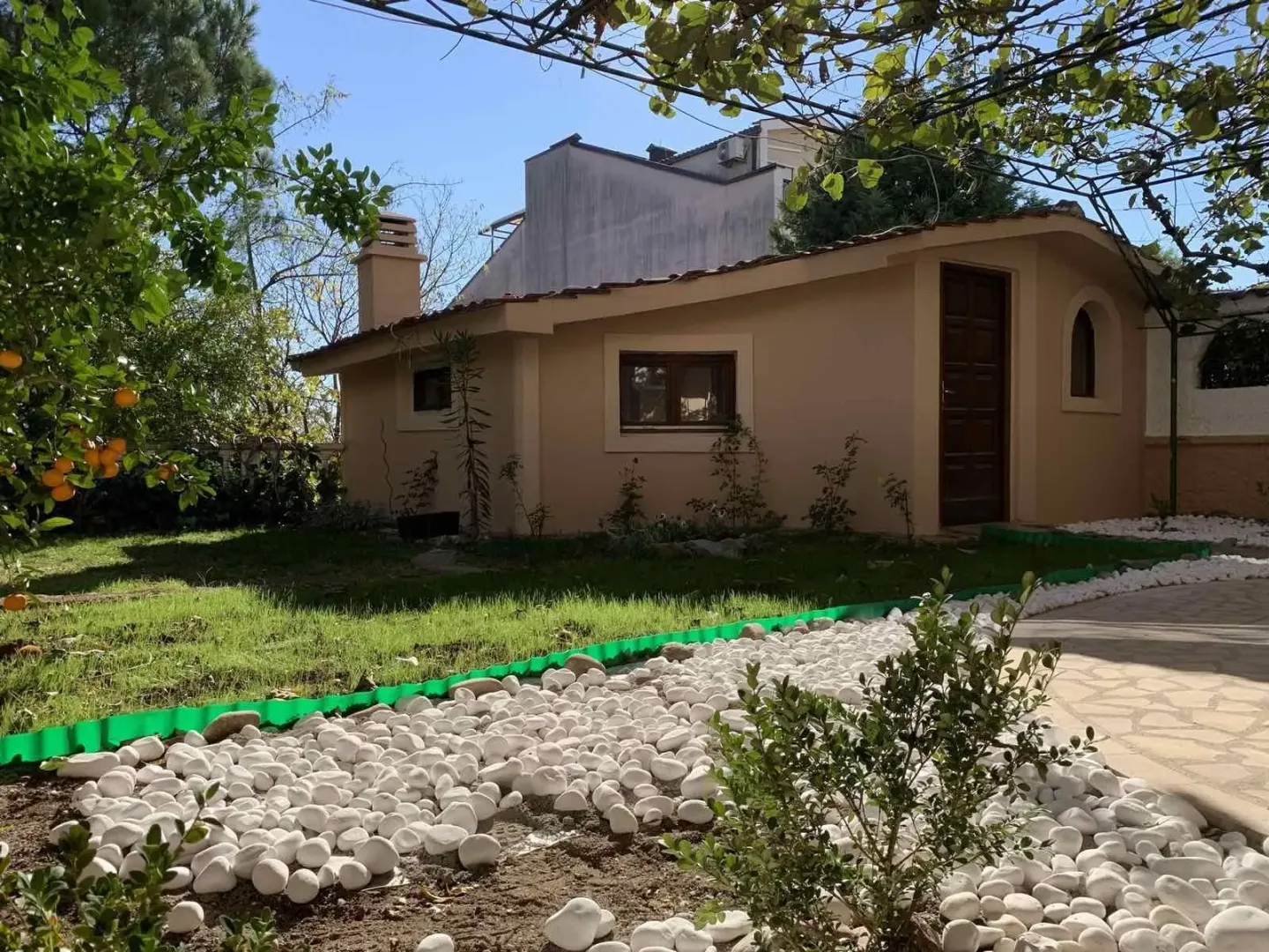 A small single-story house with a landscaped yard and decorative stones.