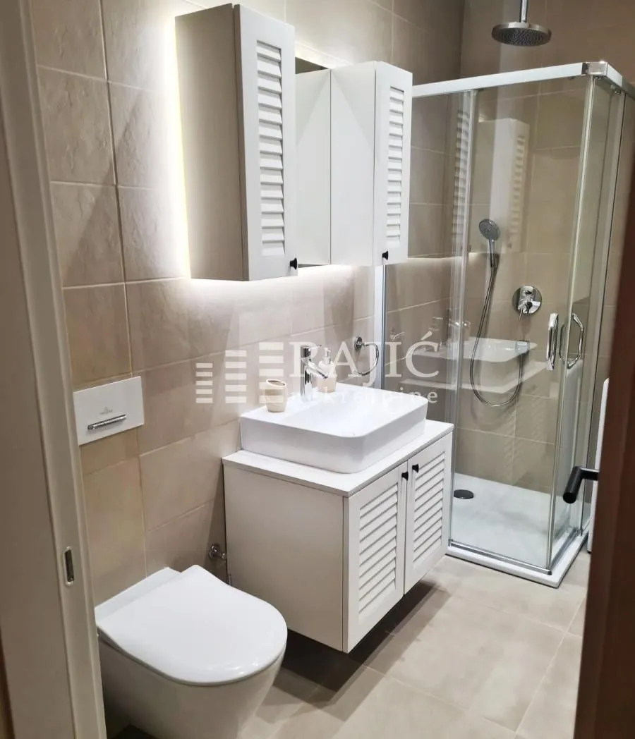Modernly equipped bathroom with a shower cabin, washbasin, and built-in sanitary ware.