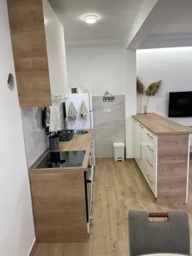 Svijetla kuhinja sa drvenim elementima i kuhinjskim ostrvom. - image 4