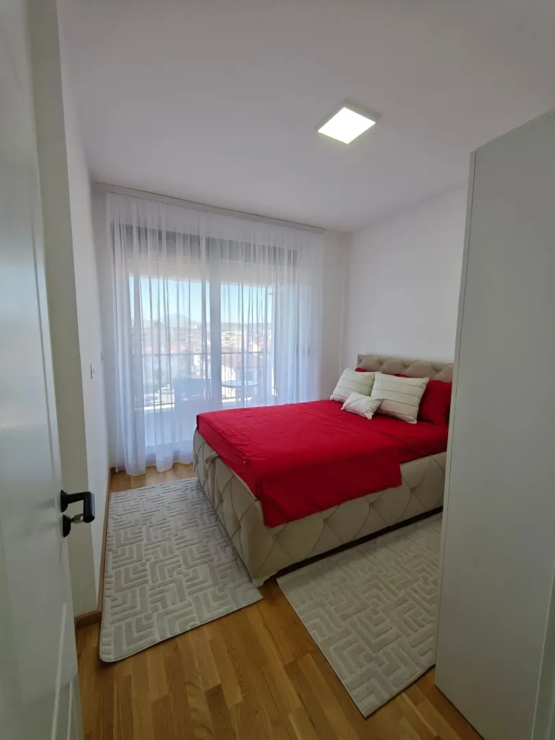 Furnished bedroom with a double bed and balcony access.