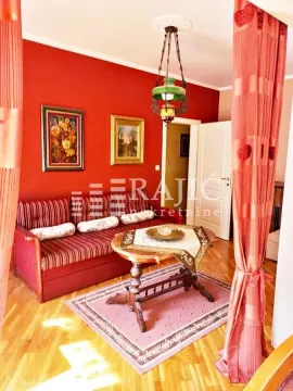Living room with red walls, a sofa, and a wooden coffee table. - image 6