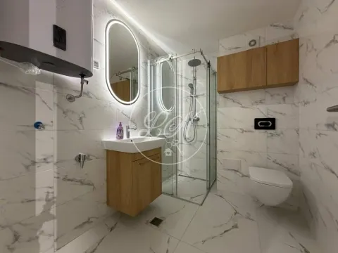 Modern bathroom with a shower cabin, washbasin, and wall-mounted toilet. - image 10