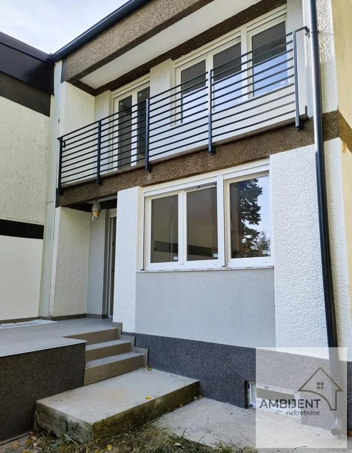 View of the exterior of the building with a balcony and entrance stairs.