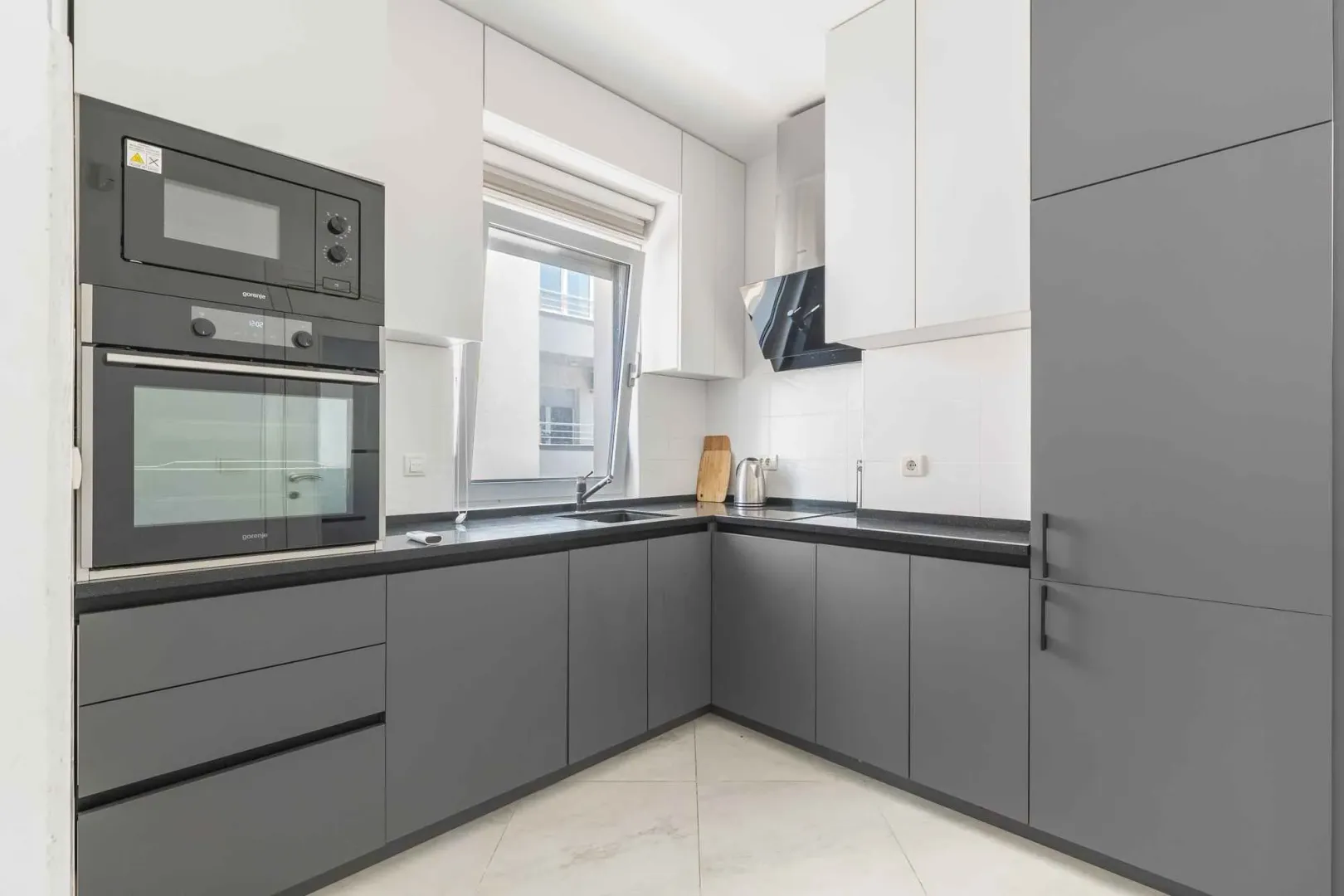 Modern kitchen with grey cabinets and a built-in oven.