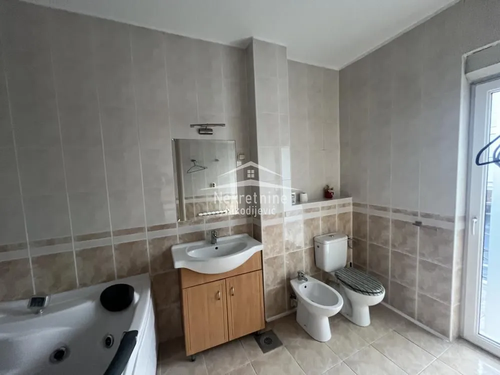 Bathroom equipped with a vanity unit, bathtub, toilet, and bidet.