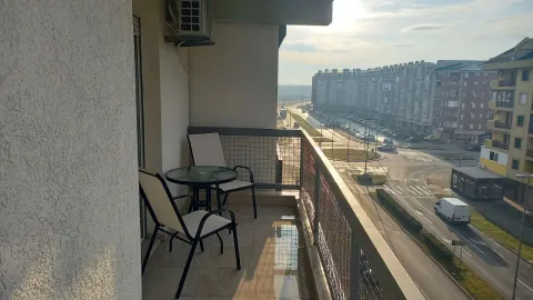 Balkon sa stolom i dvije stolice i pogledom na grad. - image 2