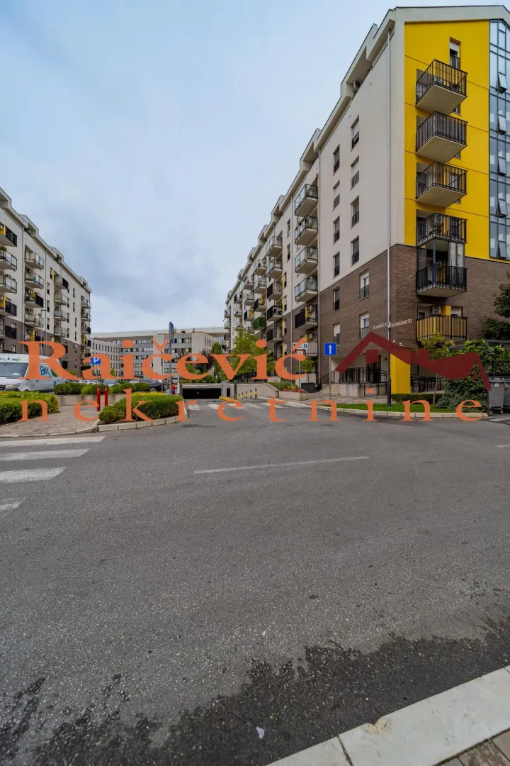 Pogled na spoljašnjost stambene zgrade i ulicu.