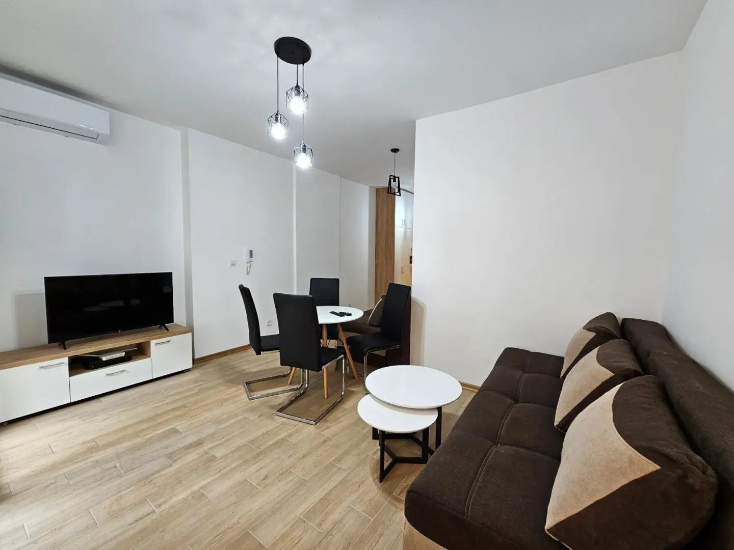 Living room with a sofa, TV, and dining table.