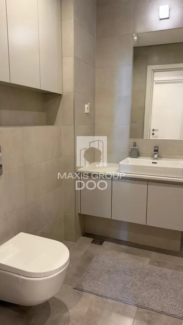 Modern bathroom with a sink, mirror, and toilet.