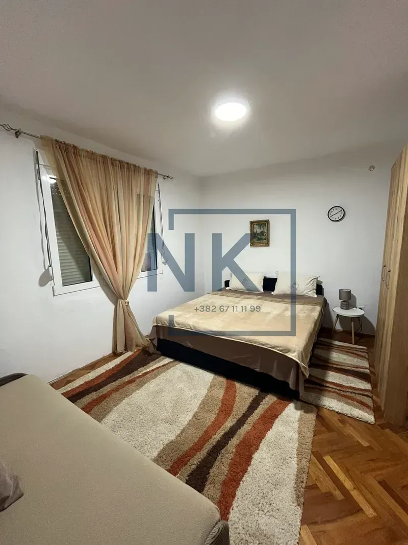Furnished bedroom with a double bed, wardrobe, and a window.