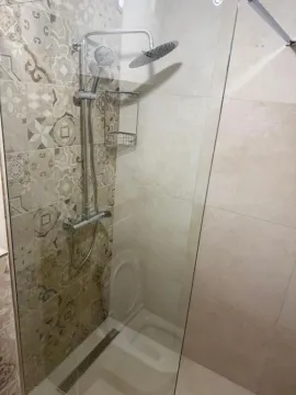 Modern shower cabin with a glass partition and decorative tiles. - image 7