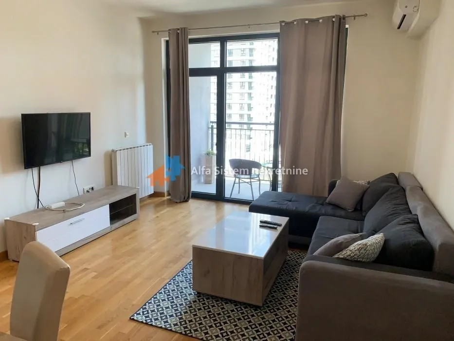 Living room with a sofa, TV, and access to the terrace.