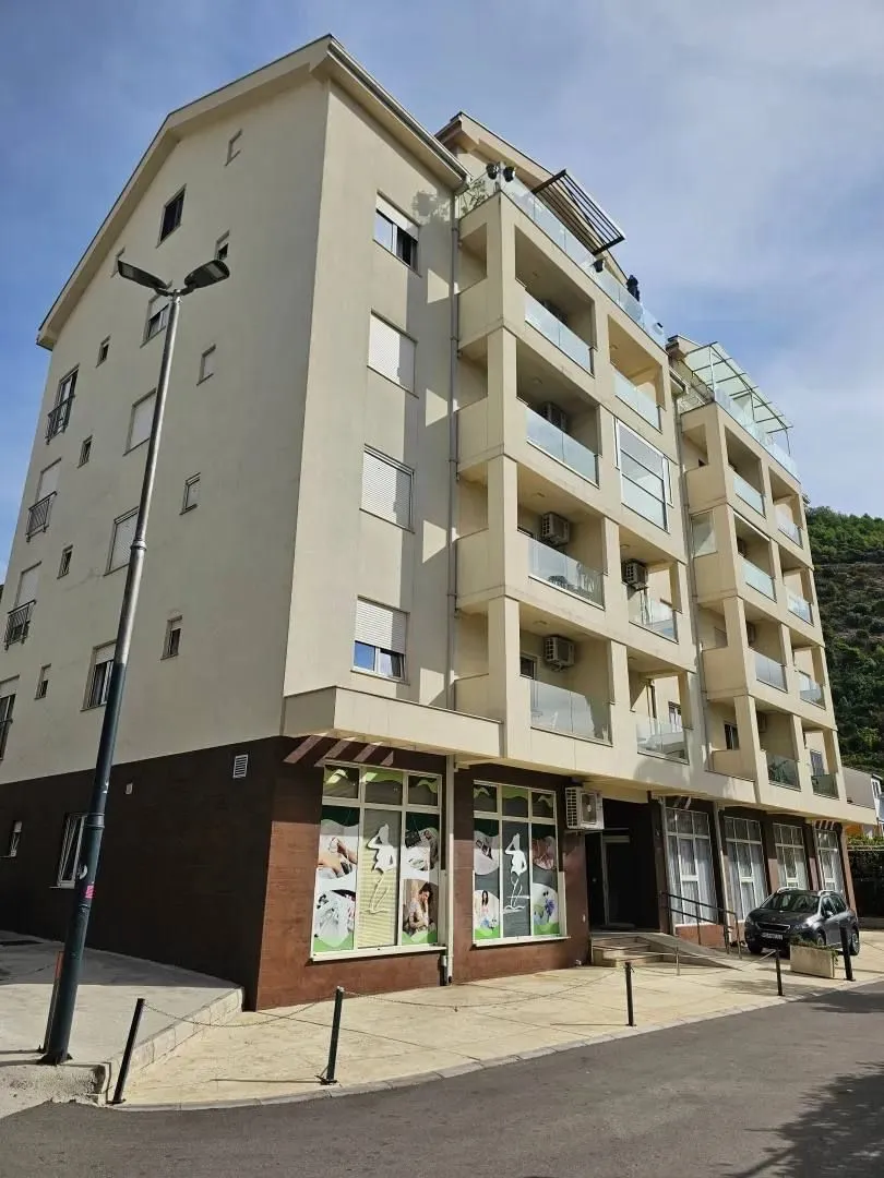 Exterior of a multi-family residential building with balconies and parking.