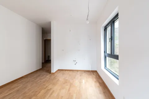 Prazna soba sa parketom, bijelim zidovima i prozorom. - image 6