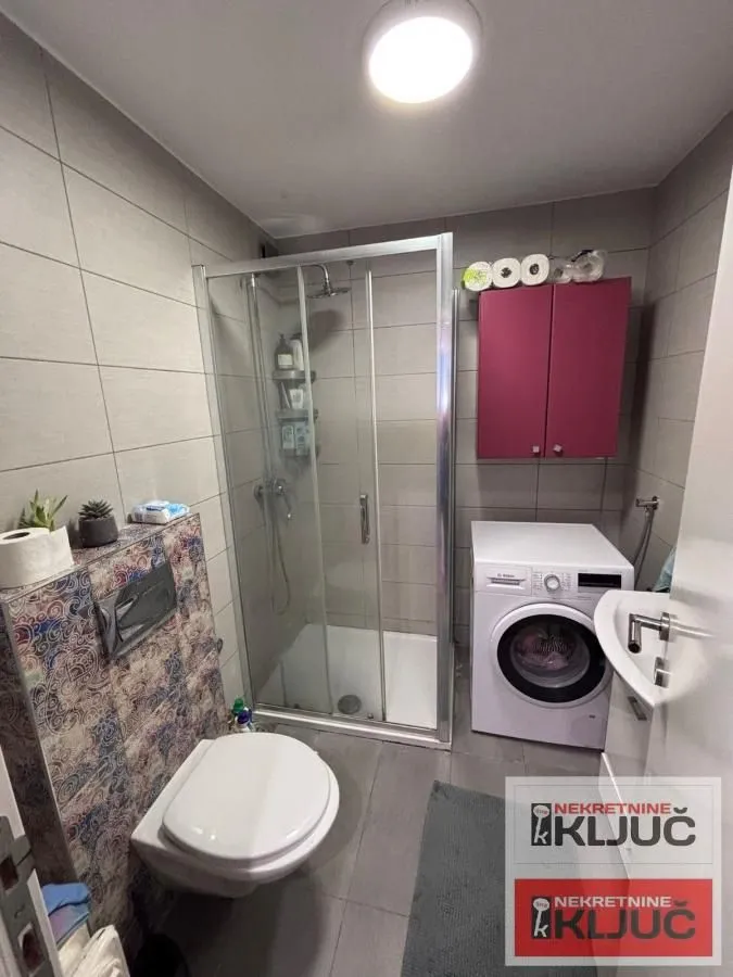 Kupatilo sa tuš kabinom, umivaonikom, WC šoljom i veš mašinom.