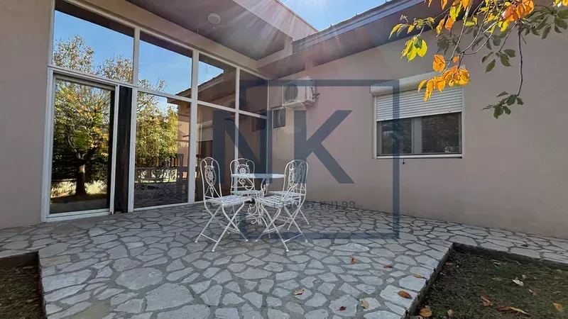 Paved courtyard with seating set in front of the house.