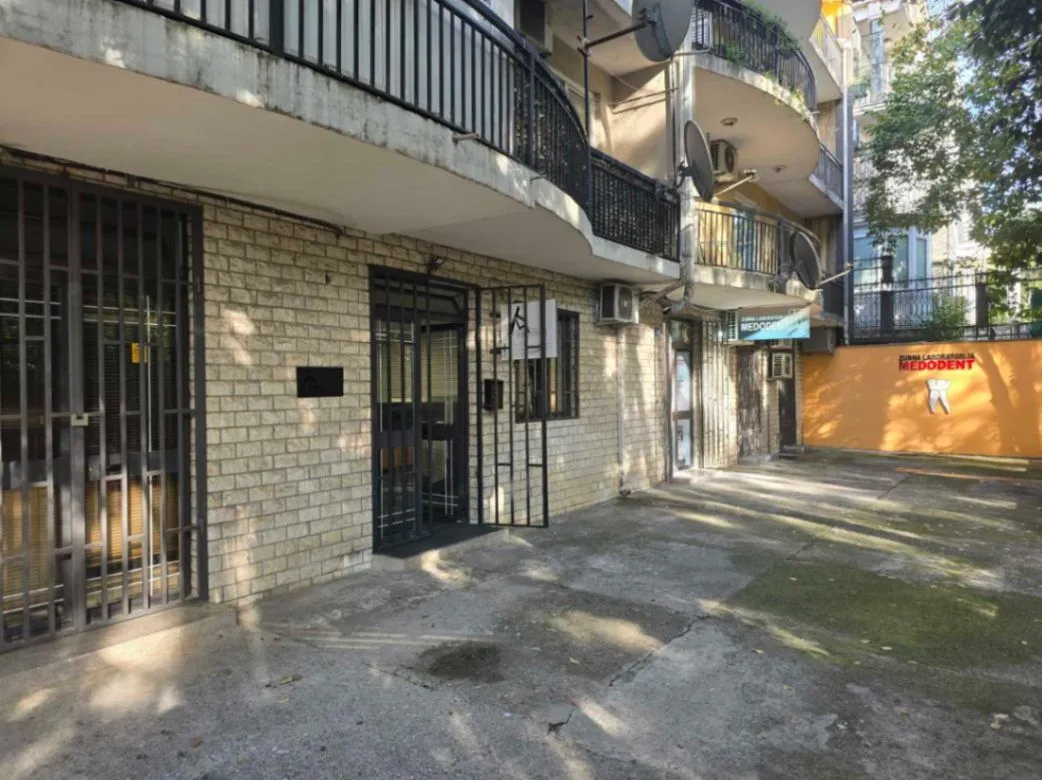 Exterior view of a residential building with an entrance and yard.